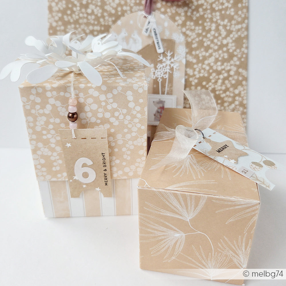 Zwei in Designpapier verpackte Geschenke mit Anhängern, auf denen 6 Merry & Bright und Merry 21 steht.