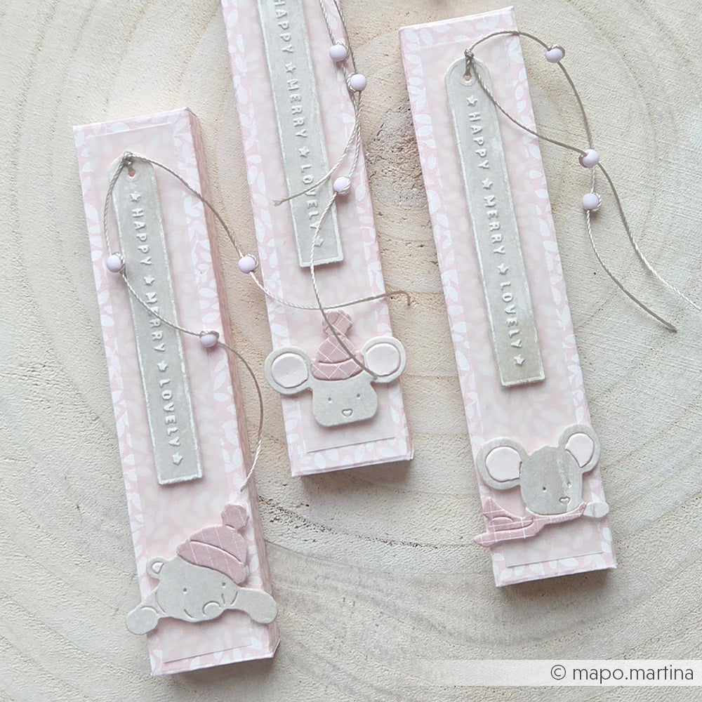 Drei hohe, rosa Geschenkboxen mit Mausmotiven, Anhängern und Akzenten aus Designpapier.