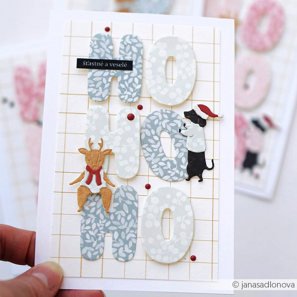 Handgefertigte Grußkarte mit einem Rentier und einem Hund mit Weihnachtsmannmütze, gestaltet mit Designpapier.