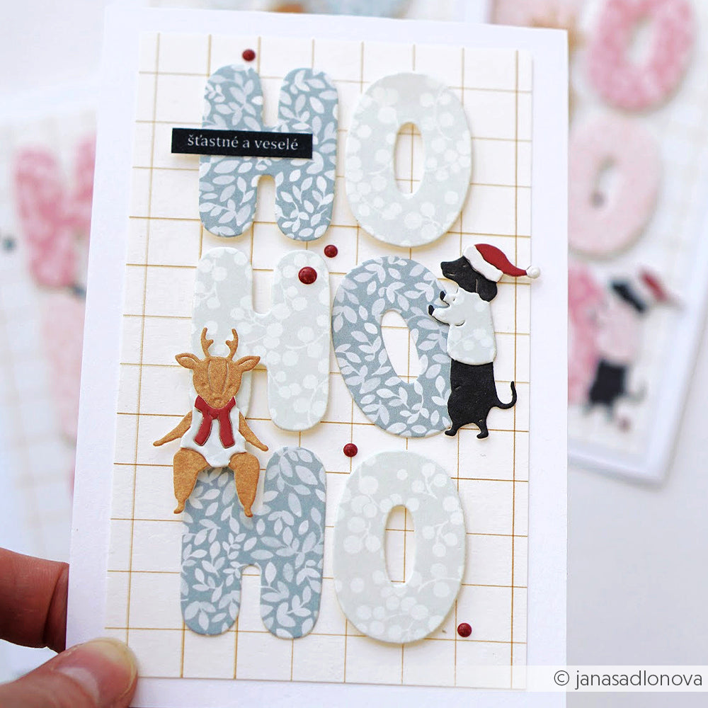 Handgefertigte Grußkarte auf elegantem blauem Designpapier mit HO HO HO, einem Rentier und einem Hund.
