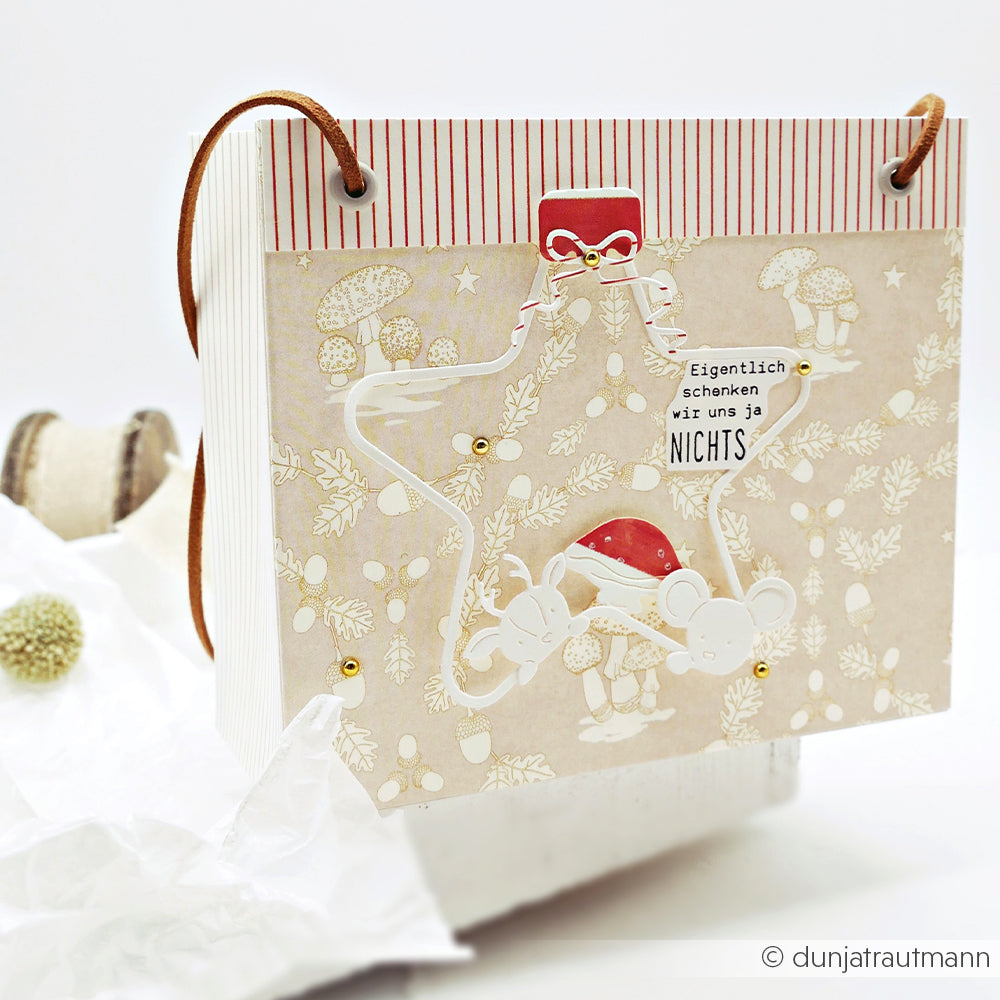 Geschenktüte mit einem sternförmigen Anhänger mit zwei Mäusen, floralen Verzierungen und deutschem Text.