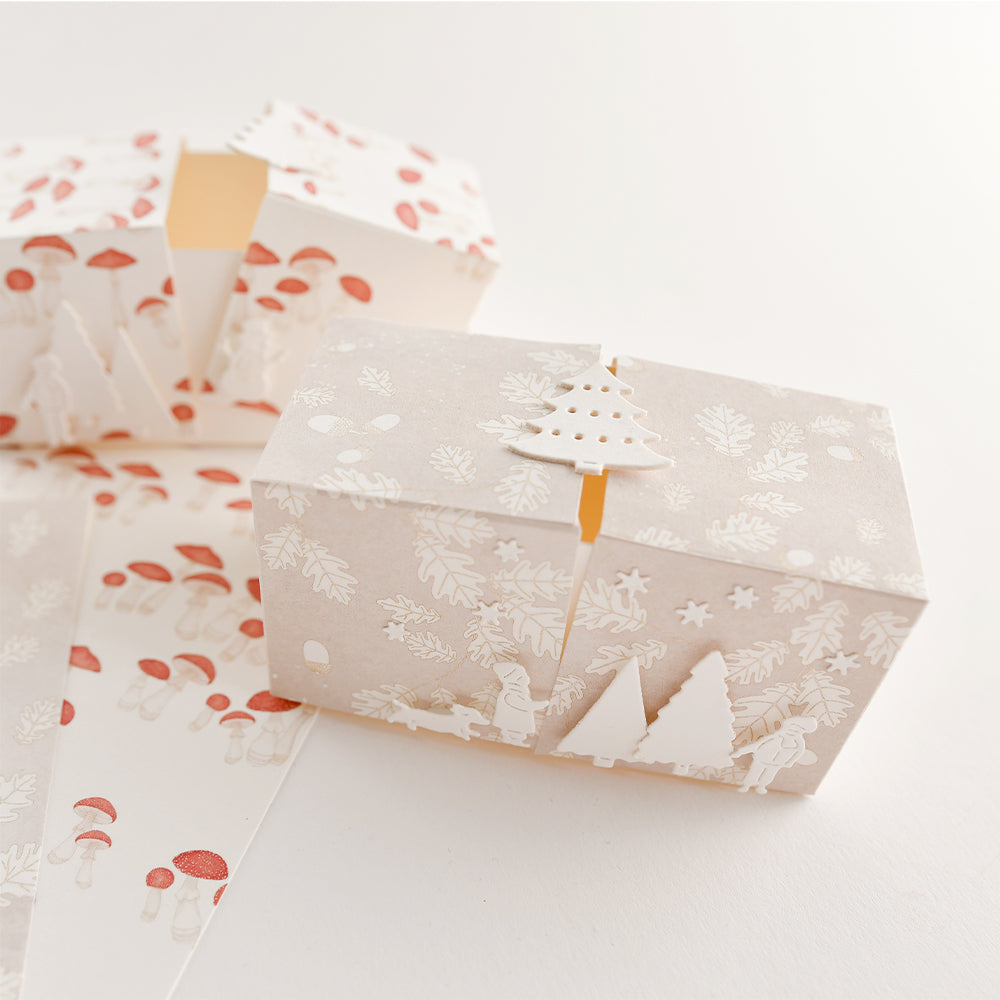 Zwei rechteckige Geschenkboxen aus Papier für „Papierprojekte“, verziert mit Motiven aus dem Winterwald.