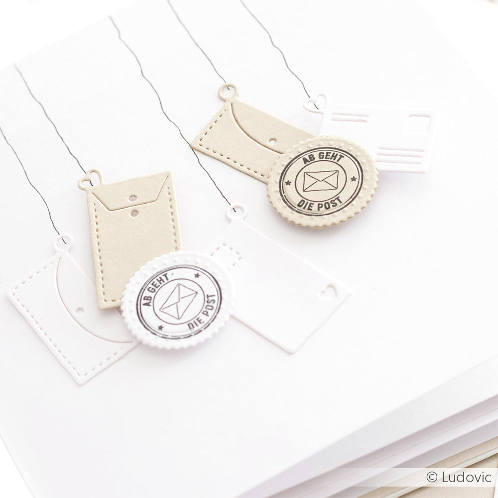 Die mit Alexandra Renke Cut & Emboss Folder und Stanzsystemen hergestellten Papierausschnitte von Briefumschlägen und Briefmarken zeigen den Text AB GEHT DIE POST" auf weißem Hintergrund.