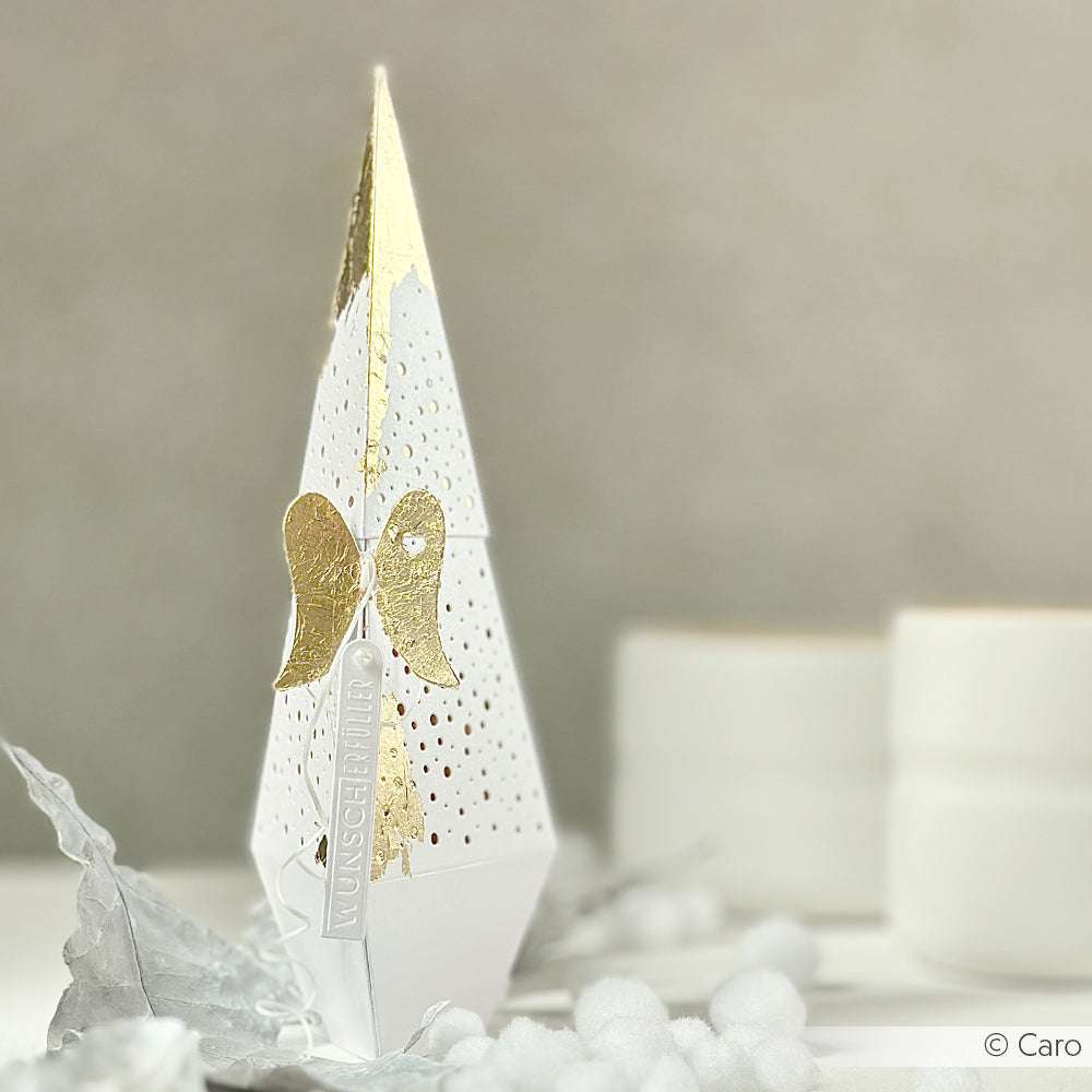 Weiß-goldener Papierweihnachtsbaum mit Engelsdekoration von Alexandra Renke, hergestellt mit DieCut Systemen für präzise Details, vor einem hellen, minimalistischen Hintergrund.