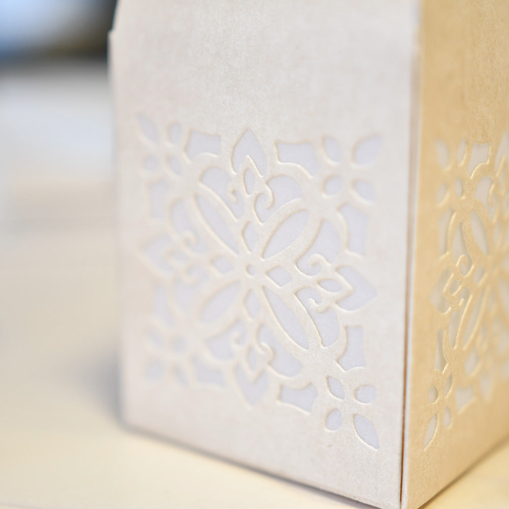 Eine cremefarbene Schachtel mit einem dekorativen floralen Ausschnittmuster auf der Seite, das mit Alexandra Renke Deep Edge Motivstanzen für komplizierte Ornamente hergestellt wurde.