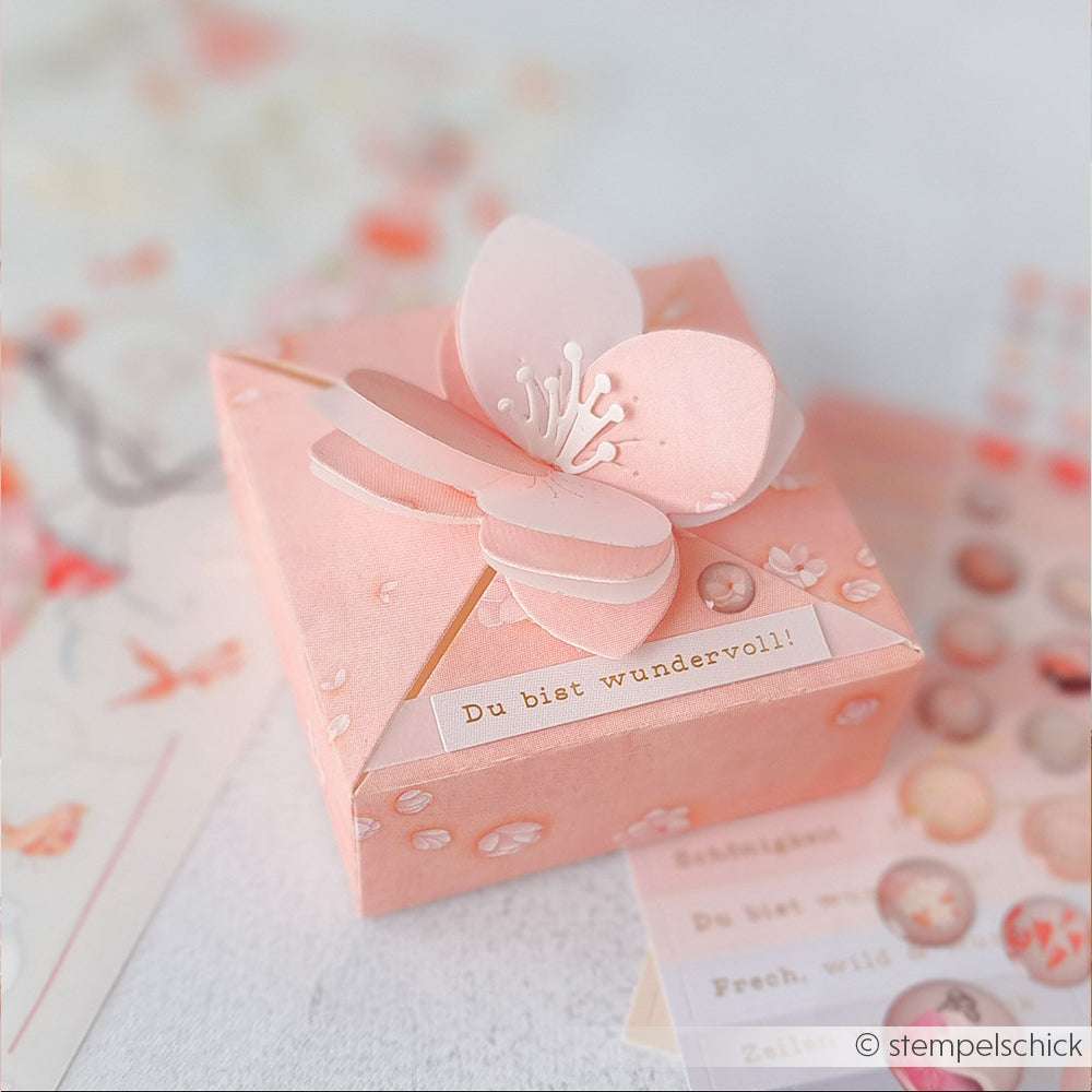 Eine rosafarbene Geschenkbox von Alexandra Renke mit einem 3D-Schmetterling aus Deep Edge Motivstanzen und der Aufschrift "Du bist wundervoll!".