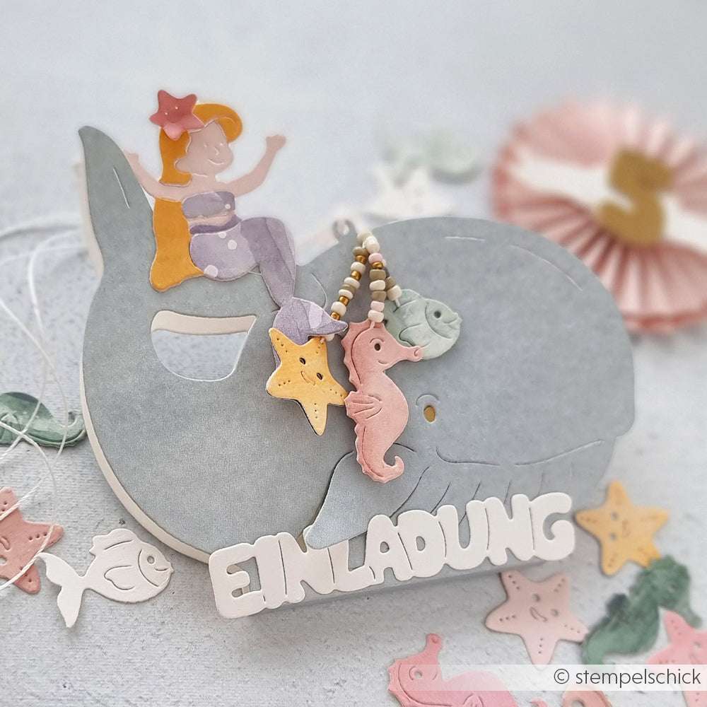 Ein pastellfarbener Wal mit EINLADUNG-Text, eine Meerjungfrau, Meerestiere, Sterndekorationen und charmante PAPPcut®ies Motivstanze-Details von Alexandra Renke.