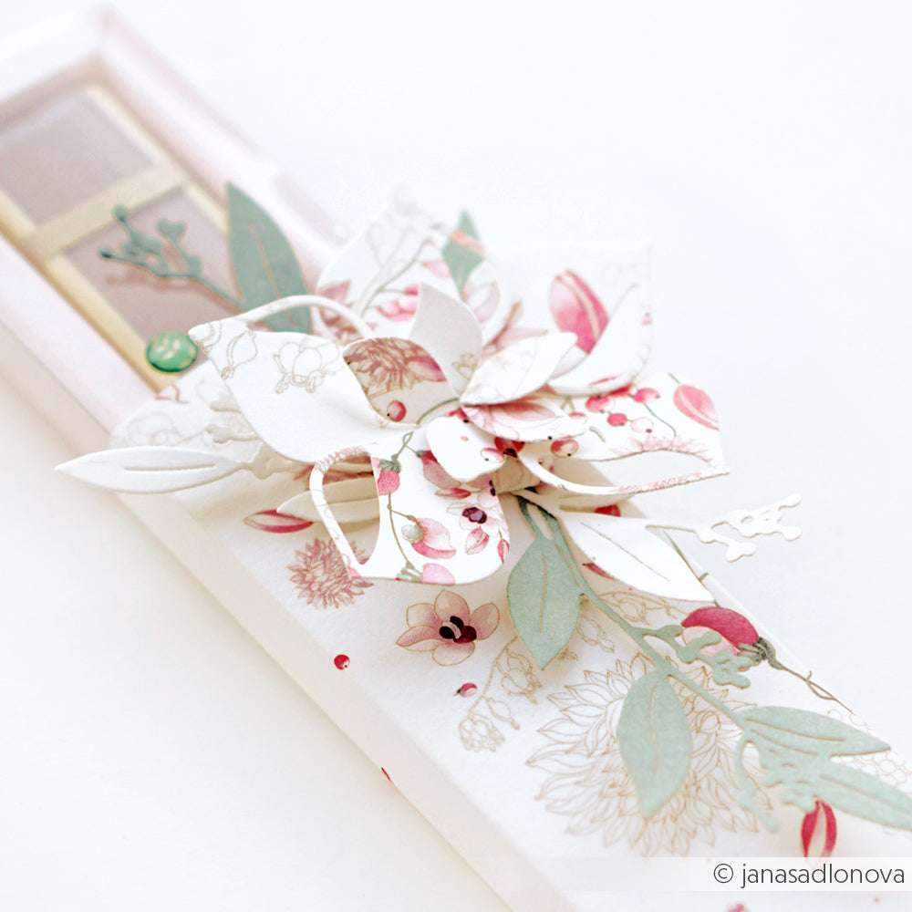 Eine rechteckige Geschenkschachtel mit einer pastellfarbenen Papierblume und grünen Blättern auf der Oberseite, hergestellt mit der PAPPcut®ies Motivstanze von Alexandra Renke für komplizierte Designs.