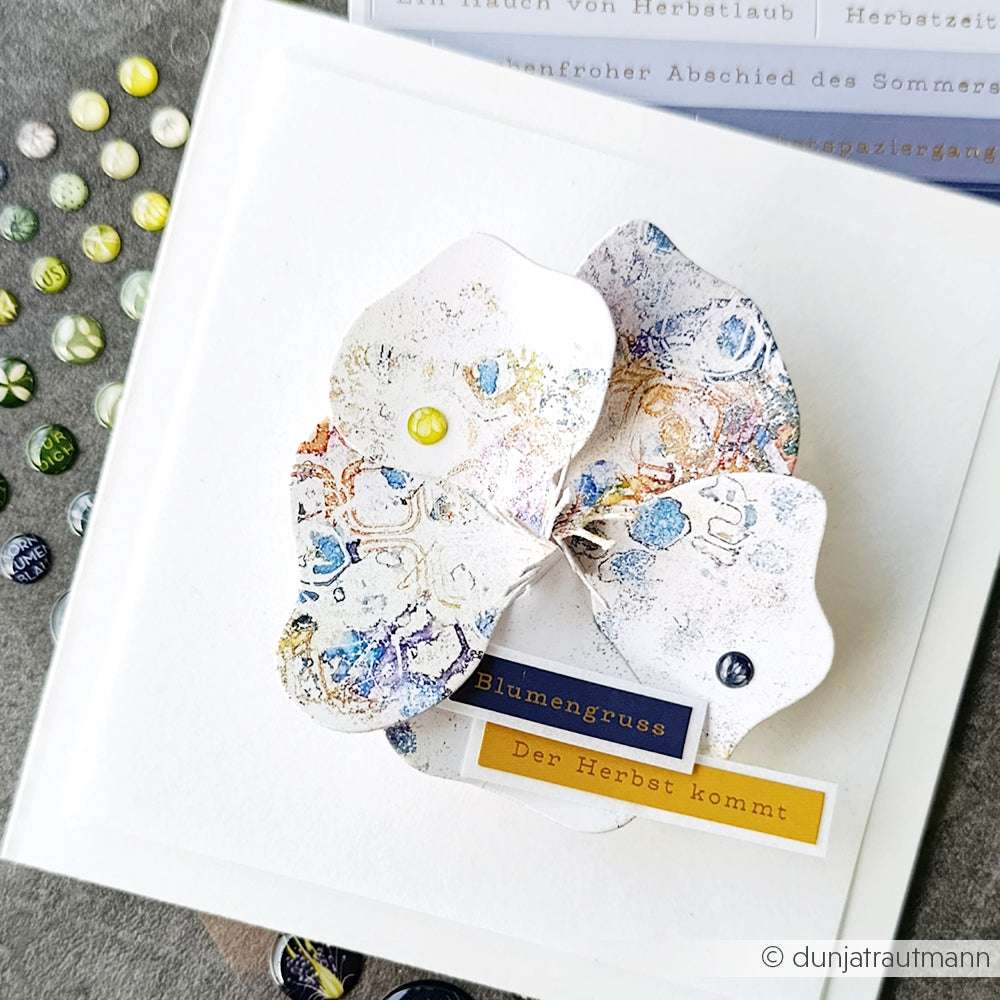 Handgefertigte Karte von Alexandra Renke mit strukturierten, geschichteten Blütenblättern mit Deep Edge Motivstanzen und Motivstanze Faltzauber-Mohn 2, dekorativen Anstecknadeln und deutschen Aufschriften "Blumengruß" und "Der Herbst kommt".