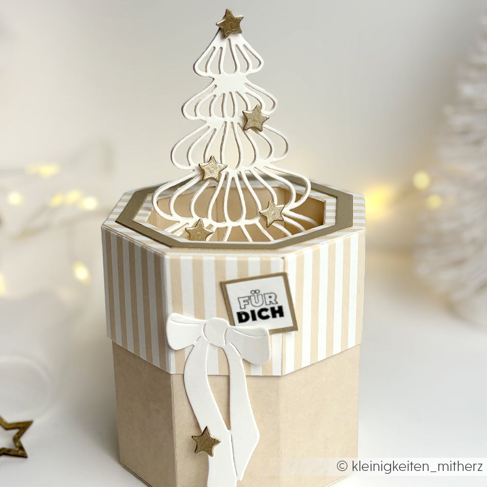 Sechseckige Geschenkbox von Alexandra Renke, gefertigt mit Deep Edge Motivstanzen, mit weißem 3D-Weihnachtsbaum, goldenen Sternen und einem "Für Dich"-Label auf dem Deckel.