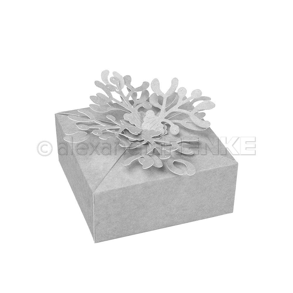 Eine graue Geschenkschachtel, verziert mit einer verschlungenen Papierblume, hergestellt mit Alexandra Renke Designpapieren und der Motivstanze Mistelzweig Box für elegante Details.