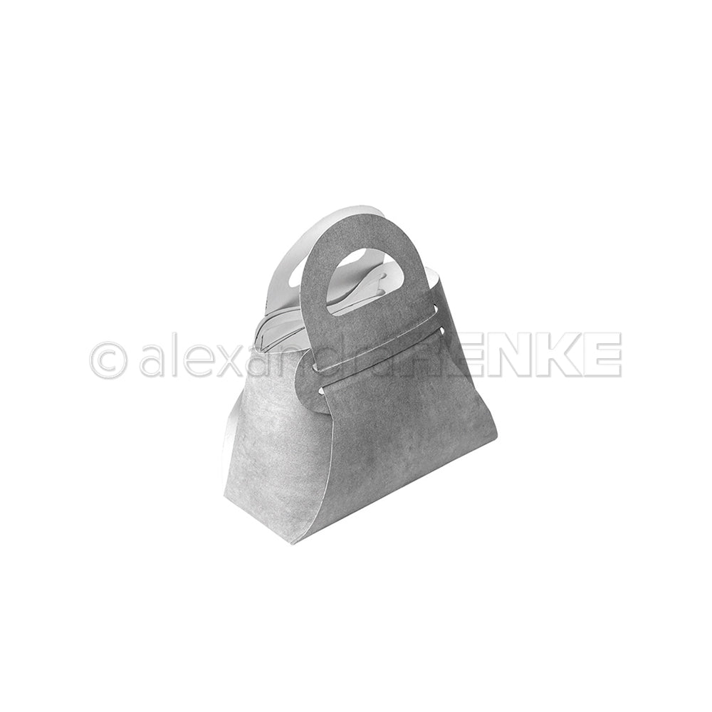 Eine graue Geschenkbox in Form einer Handtasche mit Henkel, hergestellt mit Alexandra Renke Designpapieren und Motivstanze Steck-Tasche Stanzsysteme, auf weißem Hintergrund.
