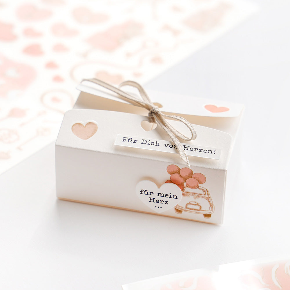 Cremefarbene Geschenkbox mit Herzausschnitten aus der Alexandra Renke Motivstanze Herzliche Schachtel, mit Schleife und den Texten "Für Dich von Herzen!" und "für mein Herz".
