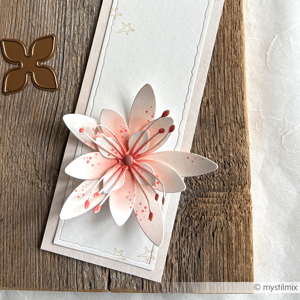 Handgefertigte Karte mit einer rosa-weißen 3D-Papierblume, die mit Alexandra Renke Designpapieren und der Motivstanze 3D Sternblume auf einer Holzfläche neben einer Metallblumenstanze gestaltet wurde.