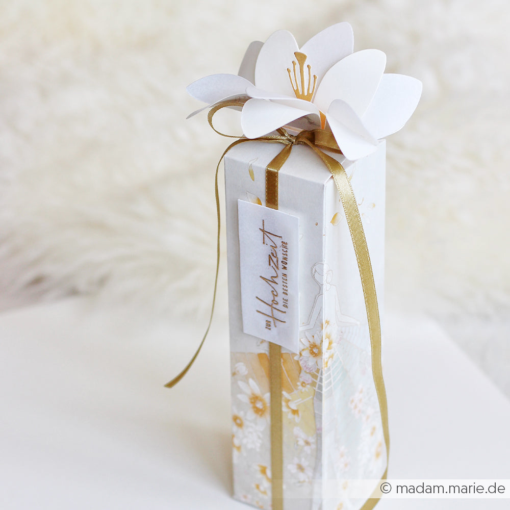 Hohe Geschenkbox mit Blumenmotiv, verziert mit einem goldenen Band und einer weißen Papierblume oben drauf, gefertigt mit der „Motivstanze Blumenbox“ von Alexandra Renke und eleganten Designpapieren; abgerundet durch ein Anhängchen mit der Aufschrift „Zur Hochzeit“.