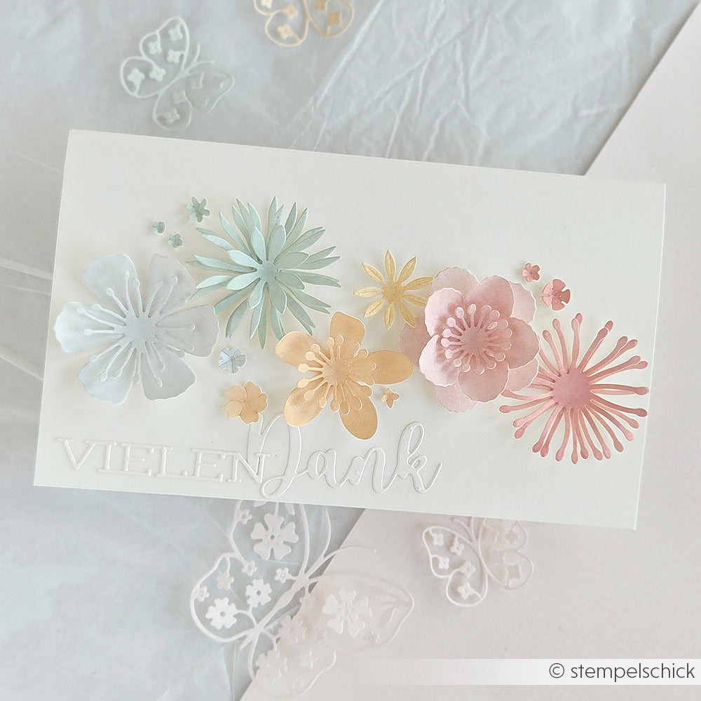 Handgefertigte Karte von Alexandra Renke mit dem Schriftzug „Vielen Dank“ und pastellfarbenen Papierblumen, gestaltet mit DieCut-Systemen und einer 3D-Pusteblume-Motivstanze auf weißem Hintergrund.