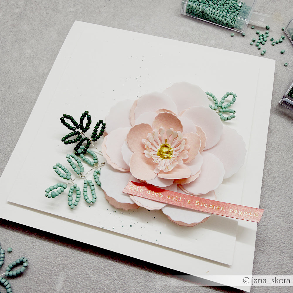 Handgefertigte Karte mit einer großen rosa Papierblume, die mit der Alexandra Renke Motivstanze 3D Wolkenrose gestaltet wurde und durch grüne Blätter mit Perlen sowie einen rosa Textstreifen in deutscher Sprache wunderschön akzentuiert wird. Hochwertige Alexandra Renke Designpapiere runden diese elegante, wahrhaft einzigartige Kreation perfekt ab.
