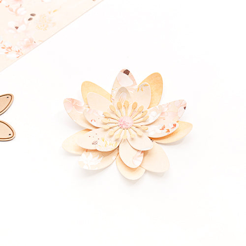 Papierblume aus Alexandra Renke Designpapieren mit mehrlagigen pastellfarbenen Blütenblättern und einer dekorativen Mitte, gefertigt mit dem Alexandra Renke Motivstanze 3D Sternensee Rose DieCut-System, präsentiert auf weißem Hintergrund.
