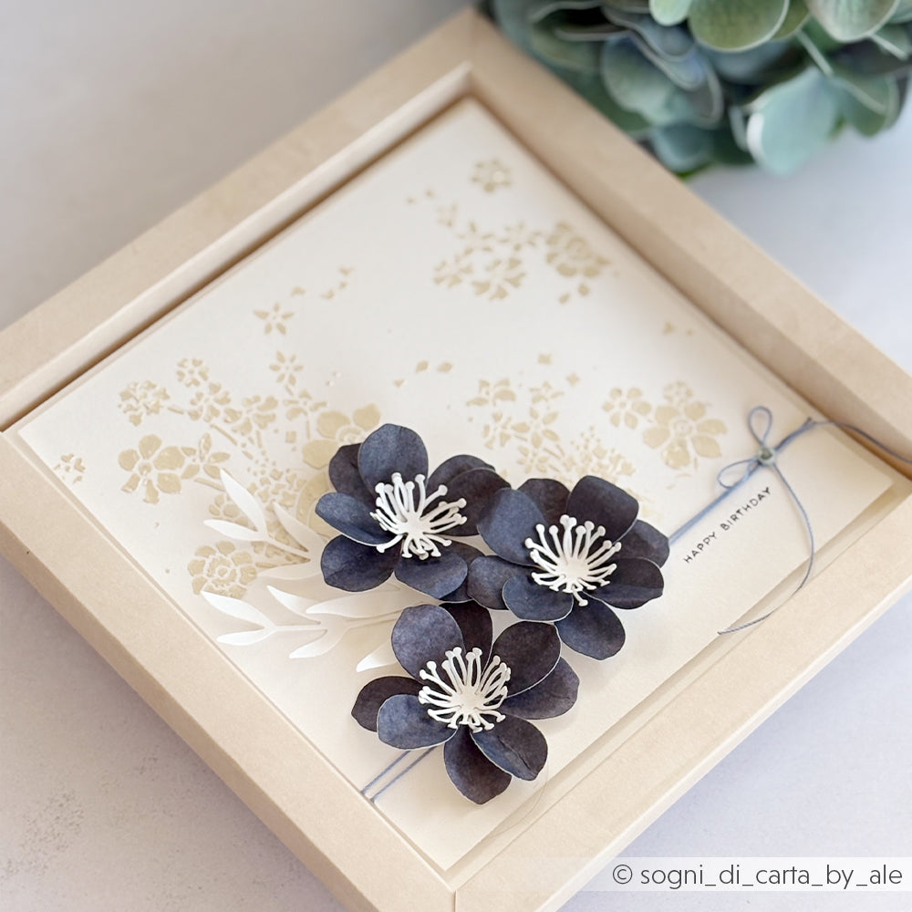Gerahmte Karte mit schwarzen Papierblumen, die mit der Alexandra Renke Motivstanze „3D Sternensee Rose“ gefertigt wurden, einem eleganten weißen Blumenmotiv sowie dem Schriftzug „Happy Birthday“, der neben grünen Blättern zu sehen ist.