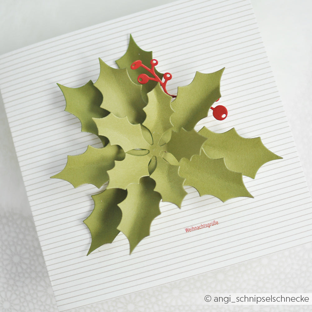 Geschenkbox, verziert mit einem 3D-Ilex-Stanzmotiv und dem deutschen Schriftzug Weihnachtsgrüße.