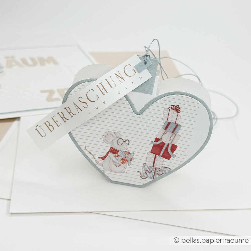 Herzförmige Geschenkbox mit einer Maus und Geschenken, gestaltet mit der Motivstanze Weihnachtskugel Box Herz.