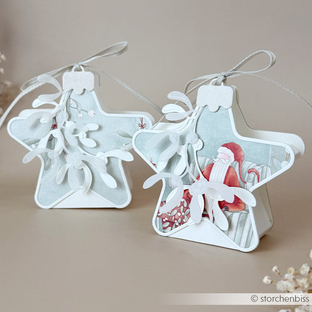 Zwei sternförmige Weihnachtsanhänger mit Weihnachtsmann und Mistelzweig, hergestellt mit DieCut-Systemen.