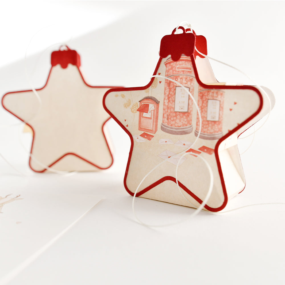 Zwei sternförmige Motivstanze-Weihnachtskugel-Box-Ornamente, verziert mit Motiven roter Briefkästen.