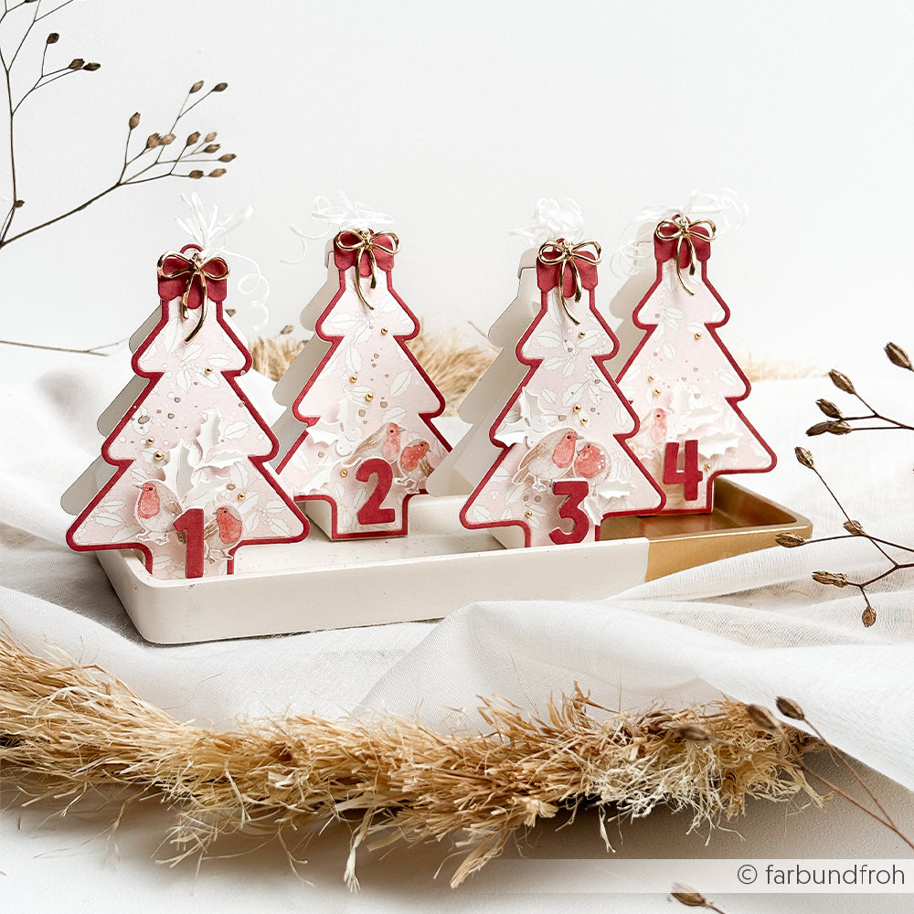 Vier Weihnachtsbaumschmuckstücke aus Papier, nummeriert von eins bis vier, hergestellt mit einer Motivstanze.