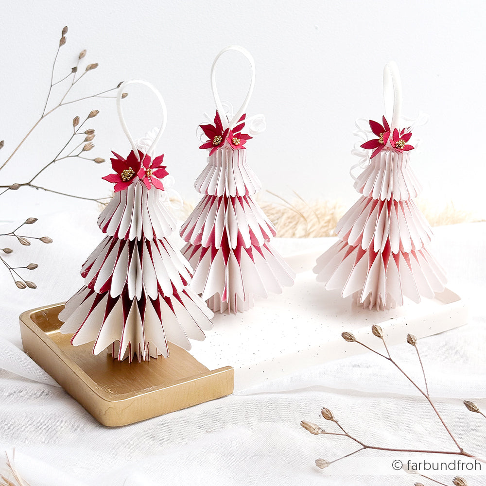 Drei Weihnachtsbaumschmuckstücke aus Papier mit roten Weihnachtssternblüten als Verzierung, hergestellt mit Stanzsystemen.