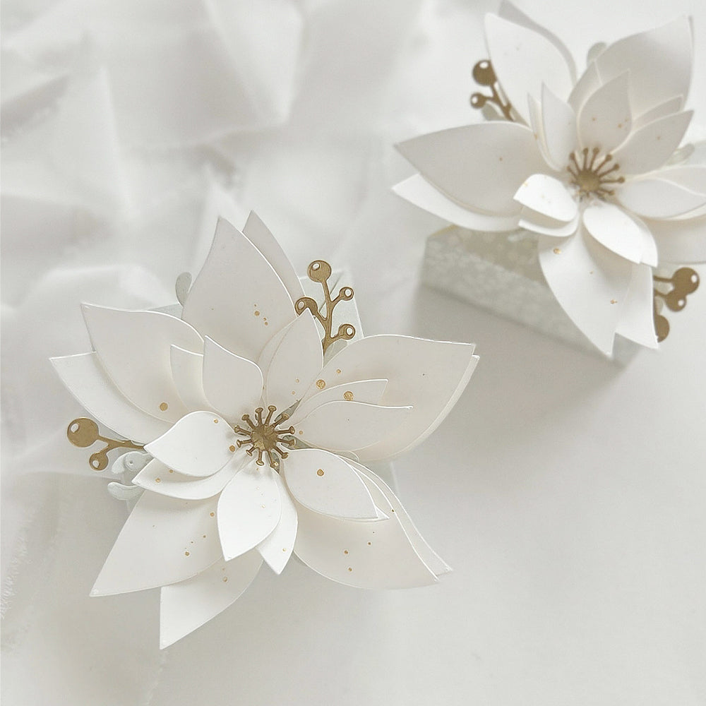 Zweischichtige Weihnachtsstern-Anhänger aus Designpapier, verziert mit goldenen Akzenten.