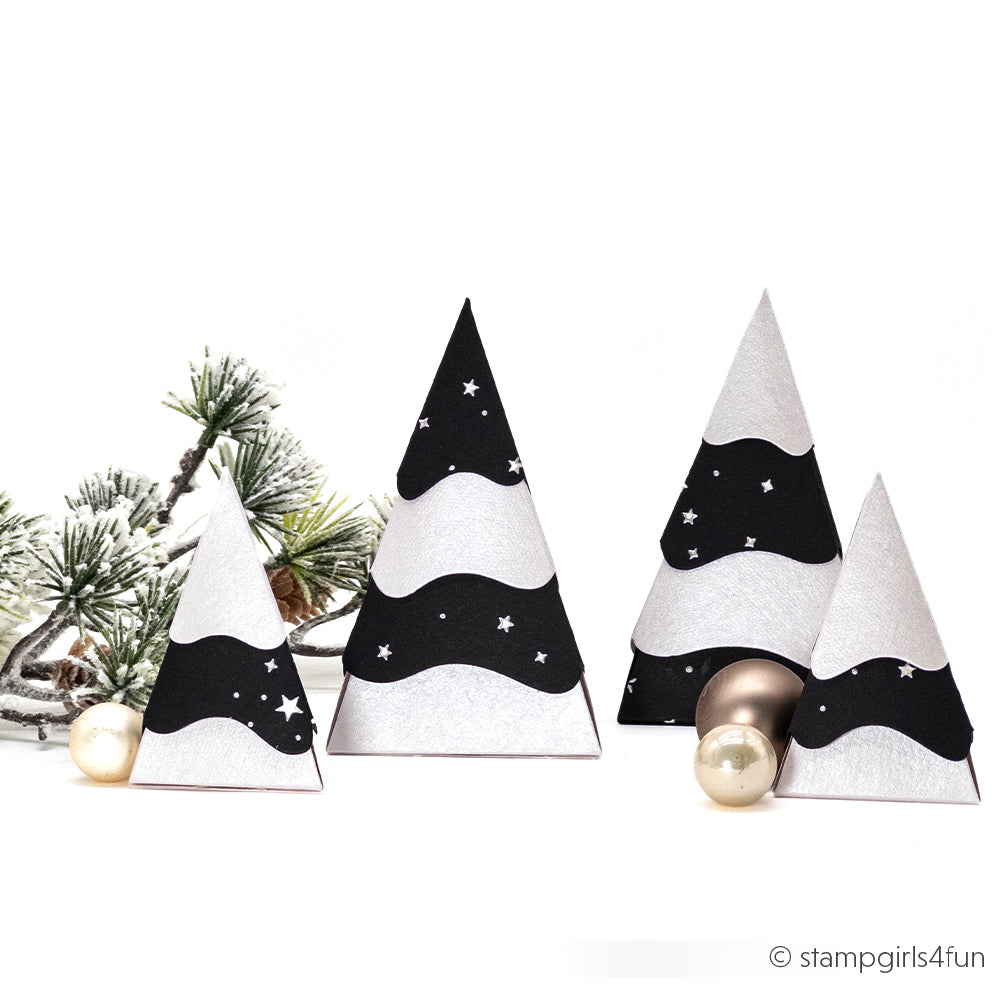 Vier Weihnachtsbäume aus Papierkegeln, hergestellt aus Designpapieren in Schwarz, Weiß und mit Sternmustern.
