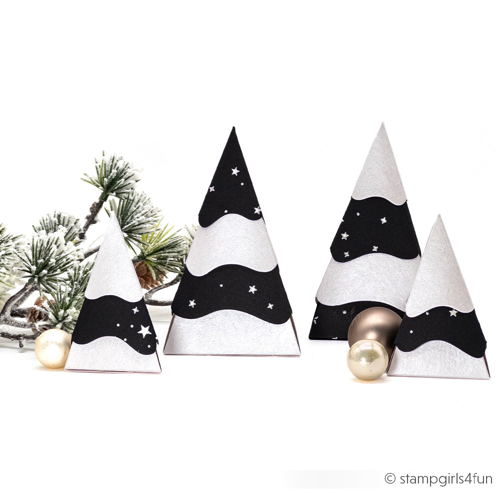 Vier Weihnachtsbäume aus Papierkegeln mit schwarzen und silbernen, wellenförmigen Sternmustern.