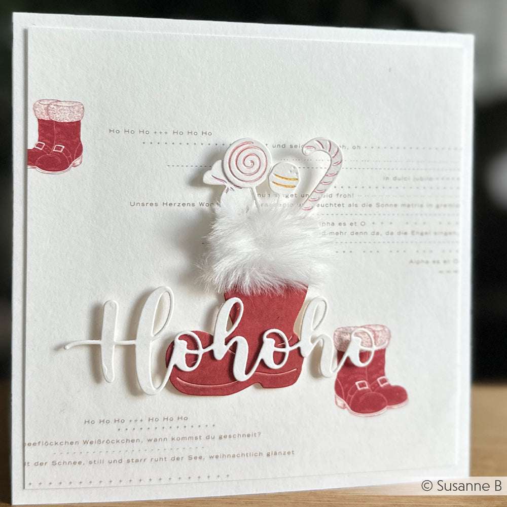 Handgefertigte Weihnachtskarte mit roten Nikolausstiefeln, einem flauschigen "Hohoho" und einem festlichen Hintergrundtext - mit Präzision und Charme aus Alexandra Renke-Produkten gestaltet.