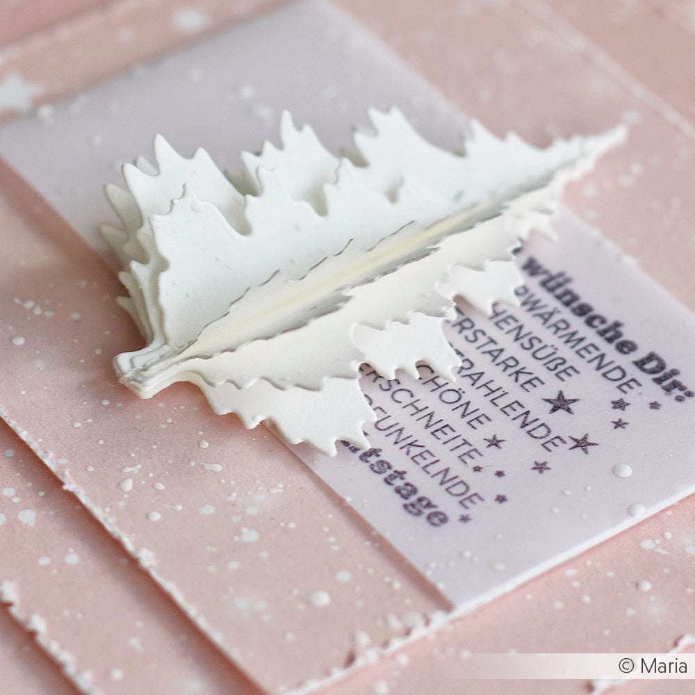 Weißer 3D-Papier-Weihnachtsbaum auf rosafarbener Karte, hergestellt mit Alexandra Renke Designpapier und einer Motivstanze, mit deutschem Text und weißen Farbspritzern als Schnee.