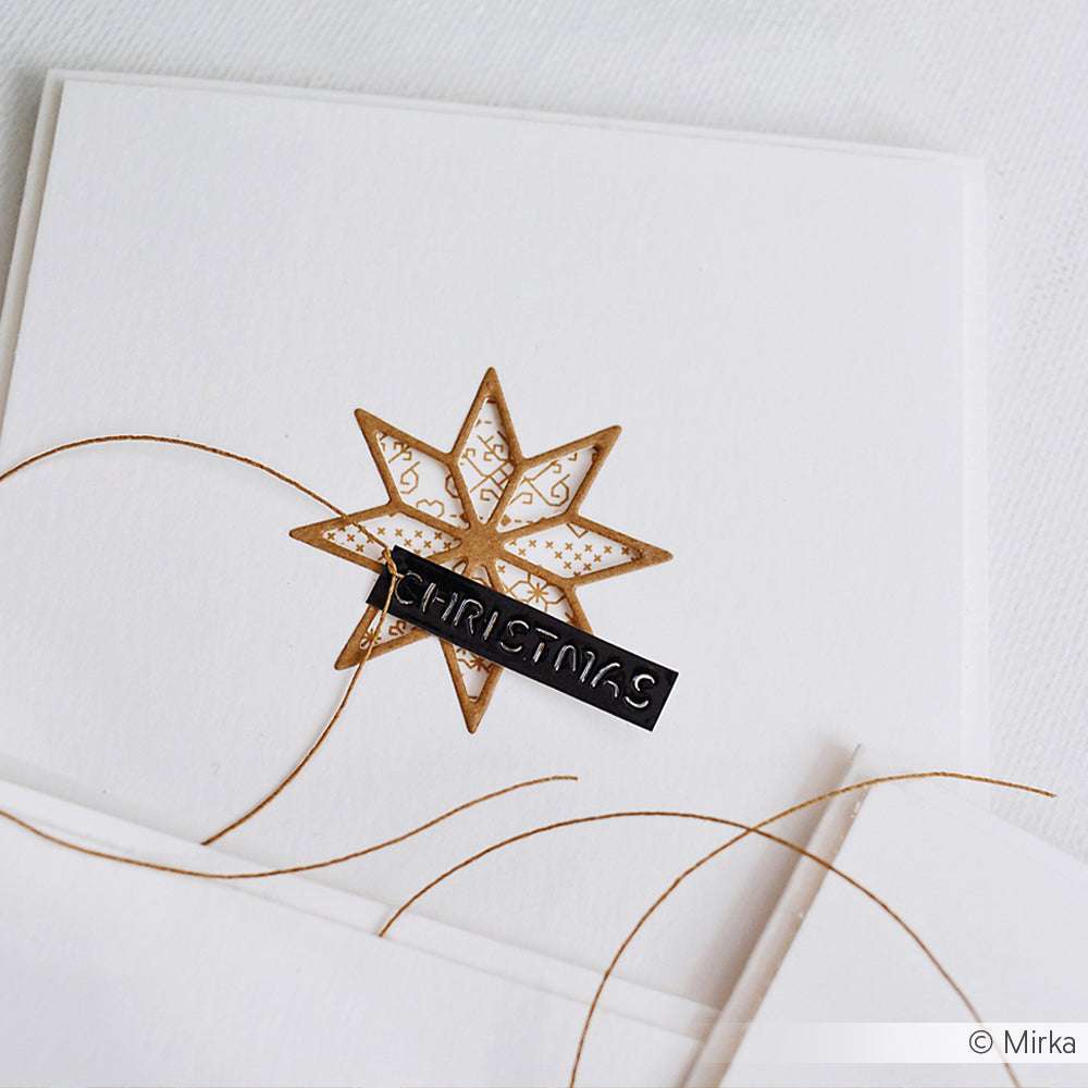 Weiße Karte von Alexandra Renke mit goldenem Stern, dünnem Golddraht und schwarzem Etikett mit der Aufschrift CHRISTMAS - ideal zum Basteln mit Stanzsystemen oder zum Aufwerten von Projekten mit Motivstanze und hochwertigen Designpapieren.