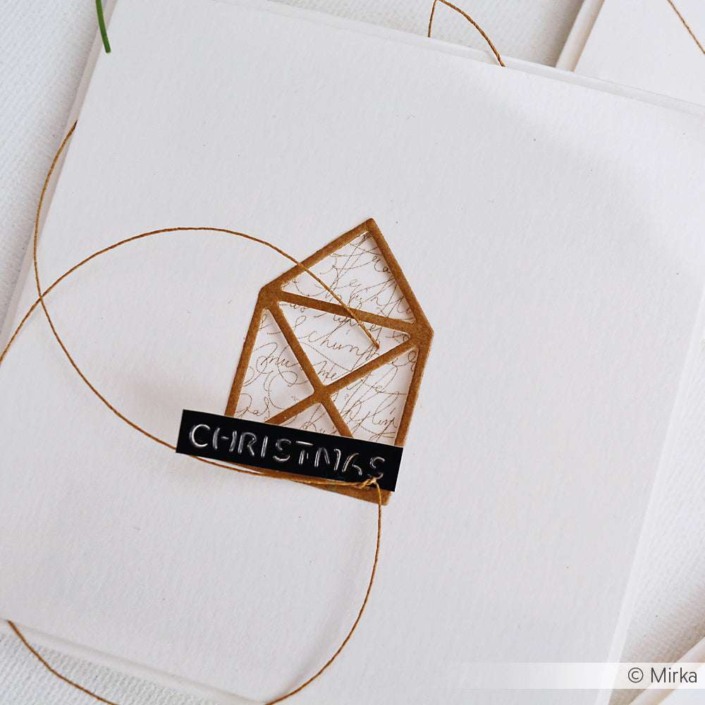 Eine handgefertigte Weihnachtskarte von Alexandra Renke zeigt ein geometrisches Hausmotiv mit Motivstanze und Designpapieren, sowie ein CHRISTMAS-Label auf weißem Hintergrund.