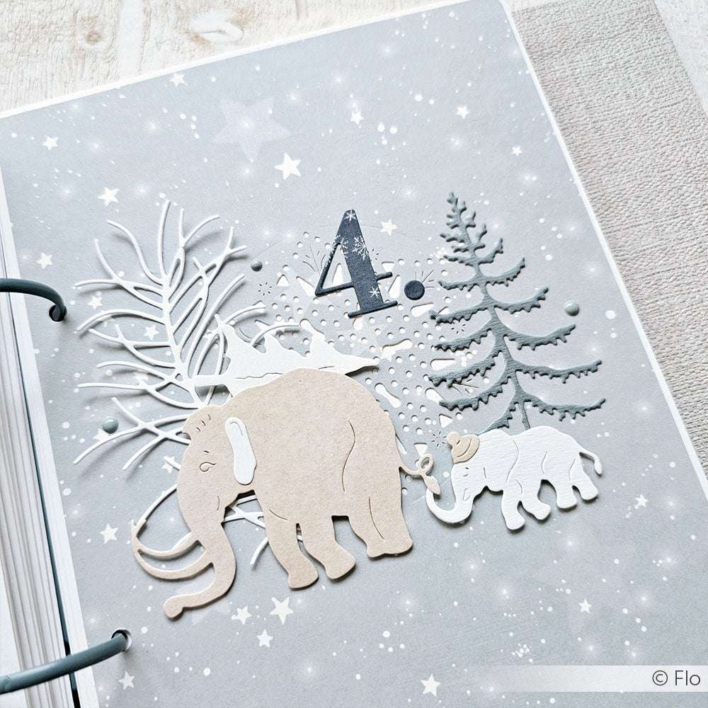 Die gestanzten Papierformen von Alexandra Renke zeigen zwei Mammuts, Bäume und die Zahl 4 auf einem sternenklaren, winterlichen Hintergrund.