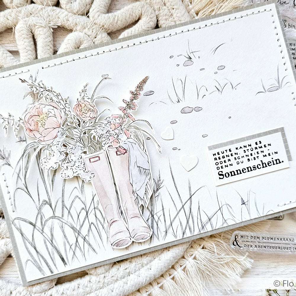 Illustrierte Karte von Alexandra Renke mit rosa Regenstiefeln, Blumen und deutschem Text auf einem weichen grasbewachsenen Hintergrund - ideal für Papierprojekte oder andere Buchbinderei-Kreationen.
