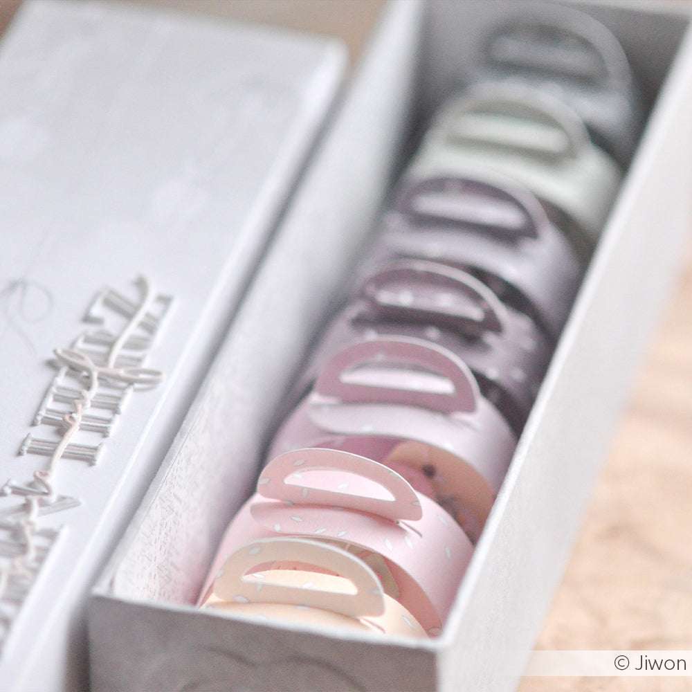 Eine Reihe von pastellfarbenen Macaron-Schachteln von Alexandra Renke in einem weißen Tablett - ideal zur Aufbewahrung von Designpapieren oder zur Präsentation Ihrer Lieblingskreationen aus der Motivstanze.