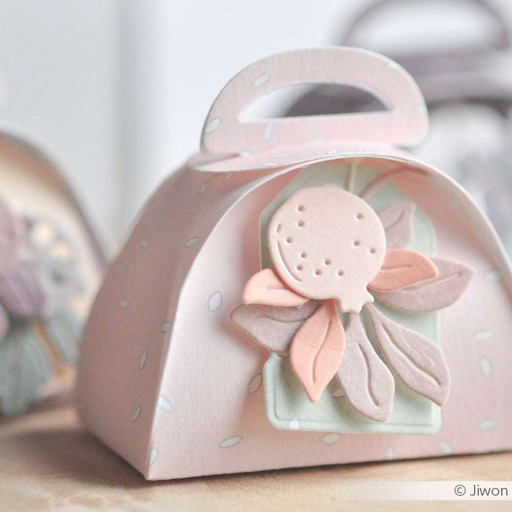 Eine pastellrosa Geschenkbox von Alexandra Renke mit einem floralen Design aus geschichteten Designpapieren und detaillierten Motivstanze-Ausschnitten.
