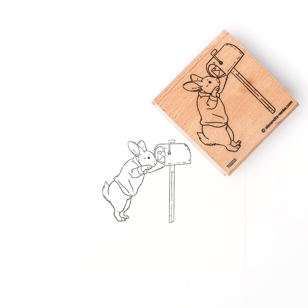 Holzstempel mit Hase Hopsi von Alexandra Renke: Der süße Stempel zeigt den Hasen auf den Hinterbeinen, wie er neugierig einen Briefkasten prüft. Perfekt für kreative Projekte, am besten mit einem Stempelkissen!.