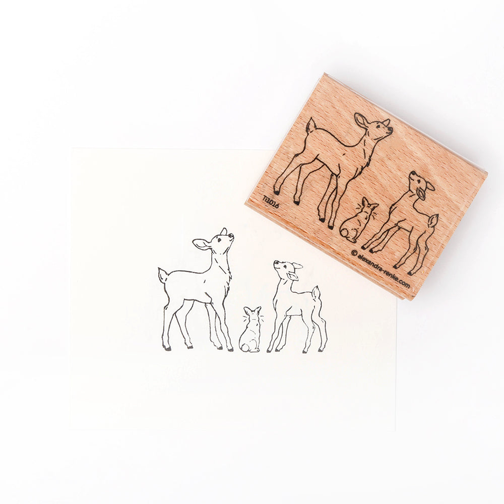 Ein hochwertiger Holzstempel von Alexandra Renke zeigt zwei Rehkitze und ein Kaninchen, daneben sind ihre Stempelmotive auf weißem Papier abgebildet.