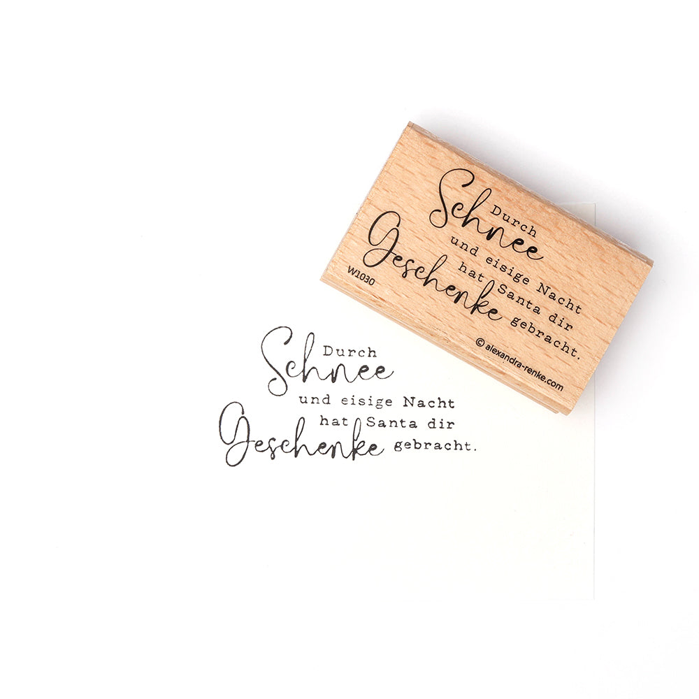 Ein Alexandra Renke Holzstempel mit deutschem Text und seinem Stempelgummi-Aufdruck auf weißem Papier, der den Weihnachtsmann und Geschenke erwähnt - ideal für festliche Papierprojekte.
