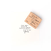 Ein Holzstempel von Alexandra Renke und Papier mit der Aufschrift "Die schönste Zeit des Jahres" in gemischten Schriftarten - ideal für Papierprojekte oder in Kombination mit Ihren Lieblingsstempelkissen.