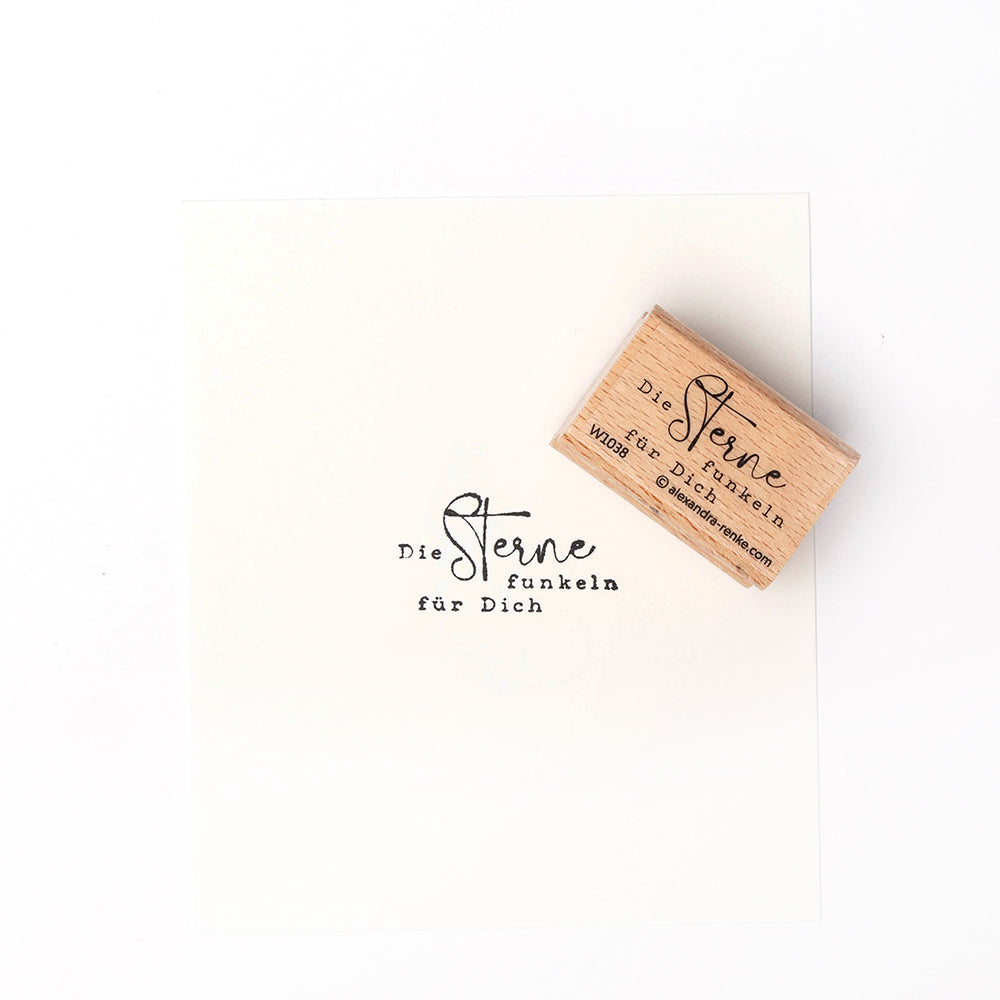 Der Holzstempel und das Papier von Alexandra Renke mit dem Text "Die Sterne funkeln für Dich" sind perfekt für kreative Papierprojekte und liebevolle Grüße.