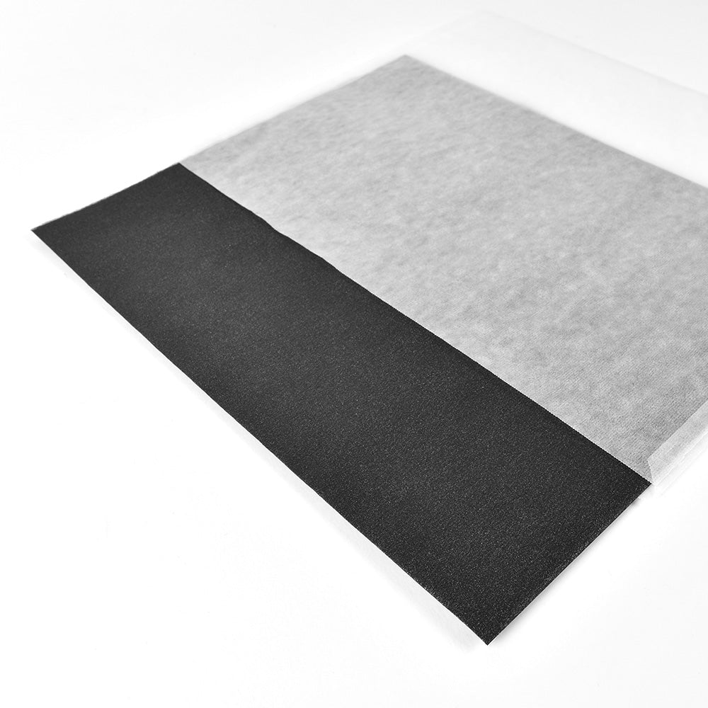 Zwei sich überlappende rechteckige Platten - eine schwarze, wie das Vivant Decorations BV Geschenkpapier Black, und eine durchscheinende weiße - liegen auf einer weißen Fläche.