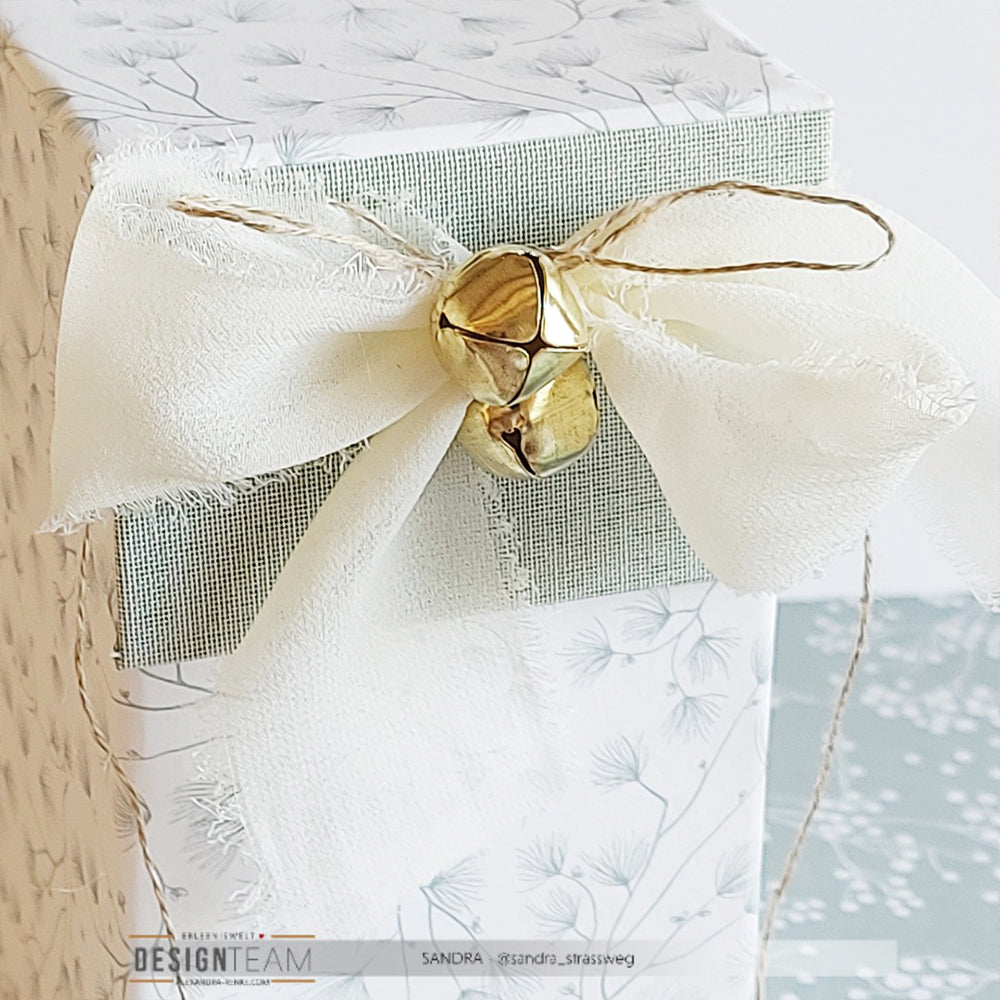 ☆ floral gemusterte Geschenkschachtel, verziert mit ausgefranster weißer Schleife, goldener Glocke, Bindfaden & Chiffonband - ideal für Deko Ideen oder charmante Bastelprojekte.