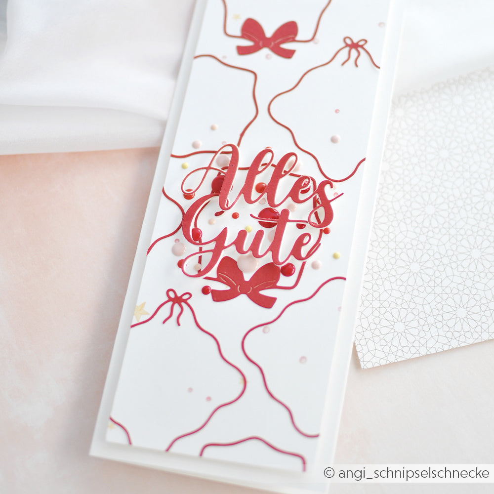 Eine weiße Grußkarte von Alexandra Renke mit roten Glockenumrissen, hergestellt mit DieCut Systemen, zeigt in der Mitte "Alles Gute!" in roter Schrift.