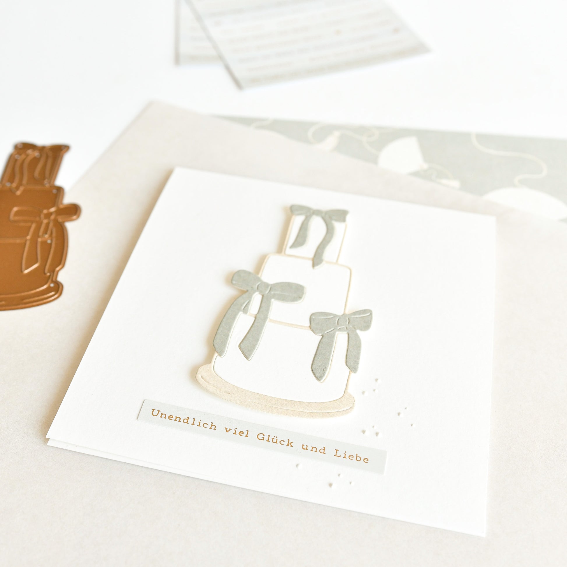 Eine Hochzeitskarte mit einer Stufentorte, Schleifen und deutschen Wünschen für endloses Glück und Liebe - wunderschön gestaltet mit Alexandra Renke Motivstanze Torte Dies für einen eleganten Touch.