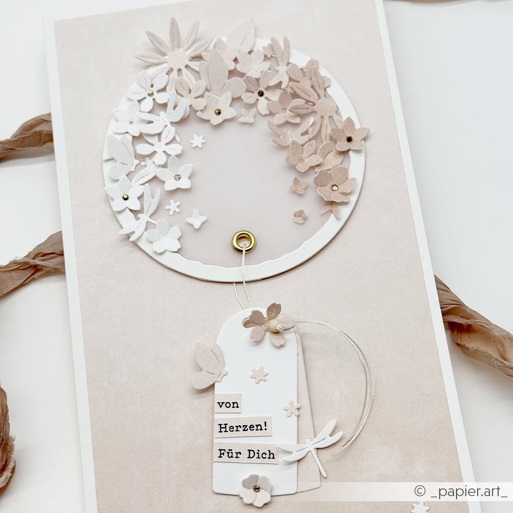 Handgefertigte Karte mit Alexandra Renke Dies für Papier und Kreis Motivstanze, mit einem geschichteten Blumenkranz und einem "Von Herzen! Für Dich"-Anhänger auf neutralem Hintergrund.